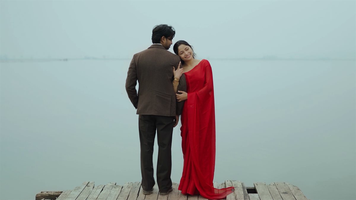 Vikram and Dipu embracing on a wooden dock over Dal Lake in Srinagar, from their pre-wedding film